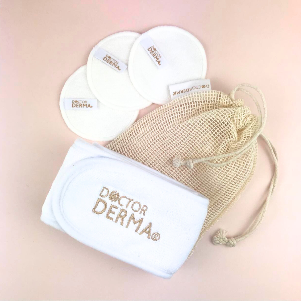 DOCTOR DERMA ECO Essential Starter Set für die nachhaltige Gesichtsreinigung. Veganer und plastikfreier Inhalt bestehend aus einem weißen Kosmetik-Stirnband, drei wiederverwendbaren Abschminkpads und einem Baumwoll-Waschsäckchen auf rosé Hintergrund.